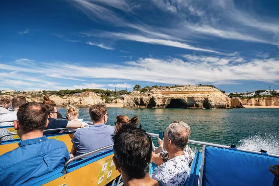 Visitors enjoy scenic views of Algarve's coastline on a boat tour, highlighting the Dreamer Caves & Dolphin Watching experience.
