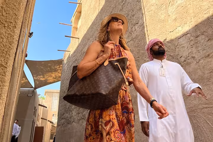 Traveler with local guide in Al Fahidi old Dubai alley, authentic heritage walk on Abu Dhabi to Dubai tour