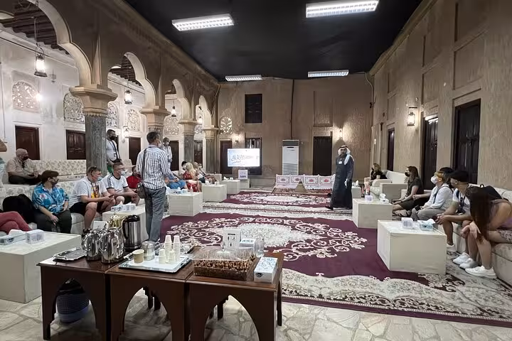 Tour guests enjoy Arabic coffee and dates at Al Fahidi historic house on Dubai city tour from Ras Al Khaimah