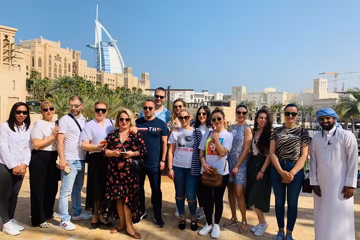 Group photo at Madinat Jumeirah with Burj Al Arab on Explore Dubai city tour pickup drop off Fujairah