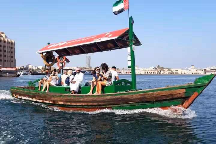 Dubai Creek abra boat ride with tourists, classic dhow on city tour before Ain Dubai entrance