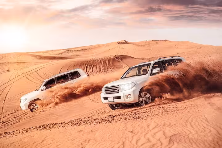 4x4 dune bashing in Dubai desert at sunrise, sand spray action on a morning desert safari adventure