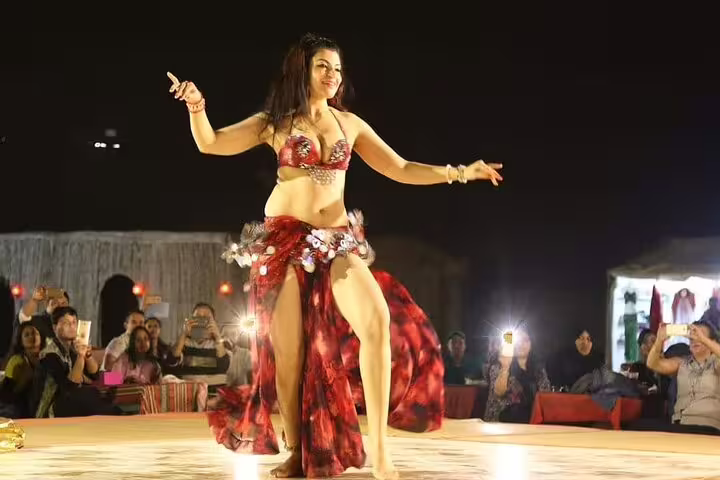 Enthralling belly dance performance at Dubai desert safari with captivated audience.