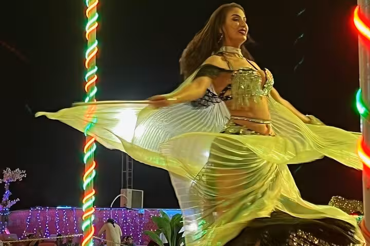 Belly dancer performing at Dubai desert camp dinner show on Evening Desert Safari with lights and music