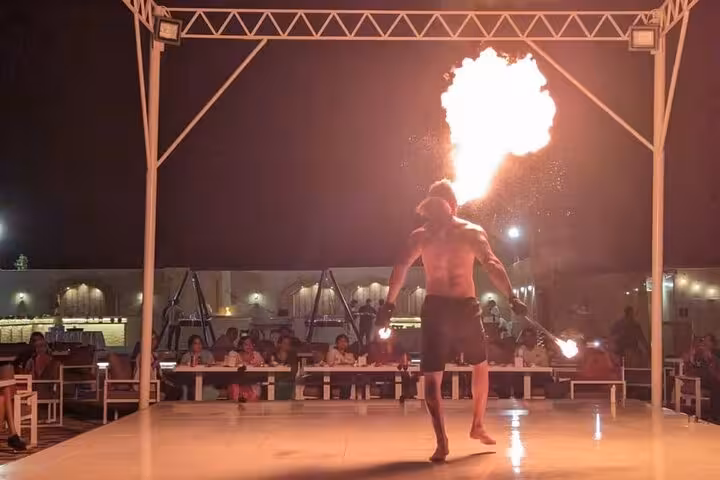 Fire show at Dubai desert camp dinner, live performance entertainment on an evening desert safari experience