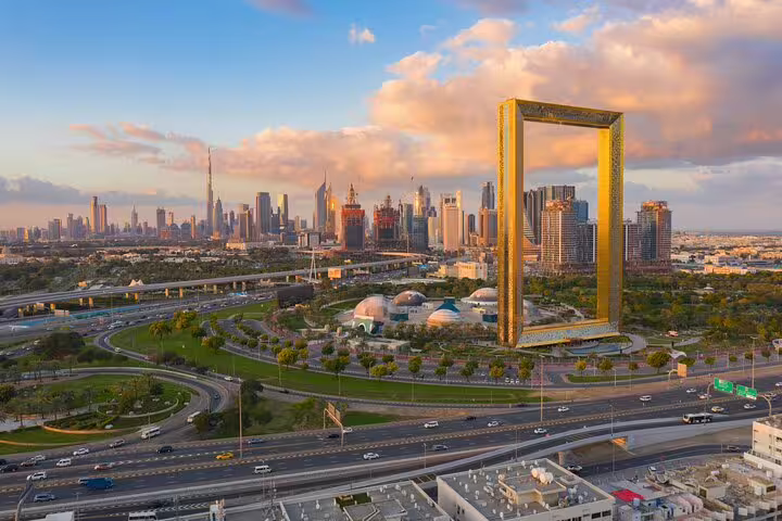 Aerial view of Dubai Frame and cityscape at sunset, highlighting a key attraction for a day and night tour.