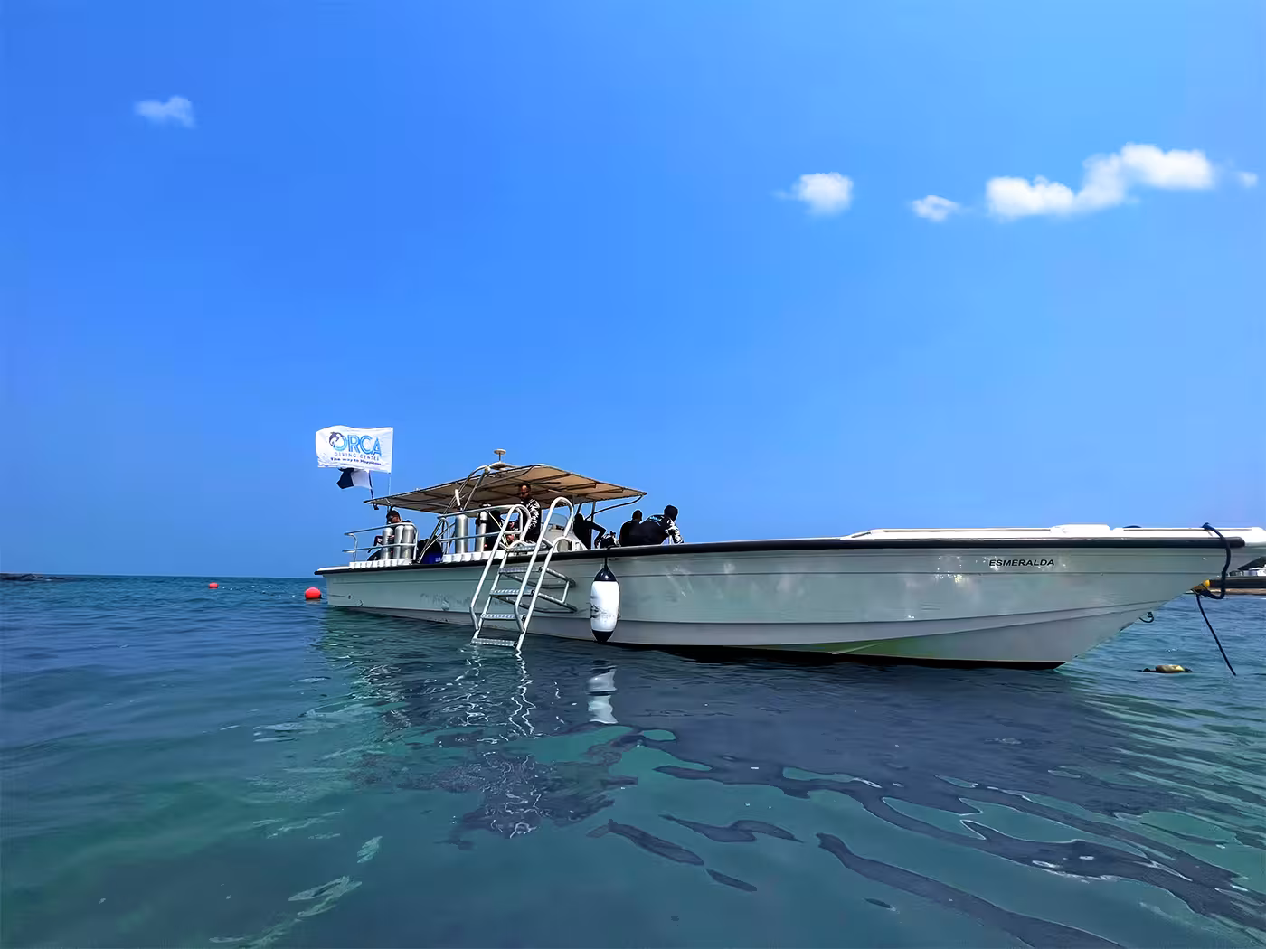 A dive boat anchored in clear waters near Fujairah, ready for the Dubai to Fujairah dive adventure with a scenic BBQ transfer.