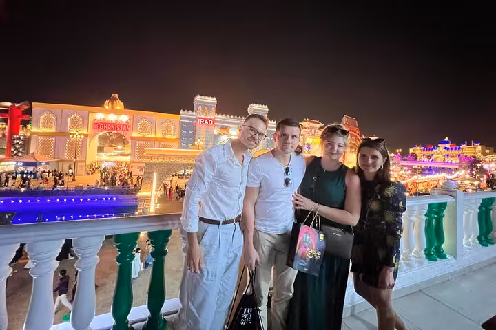 Friends at Dubai Global Village at night, lively pavilions and lights on private tour with pickup