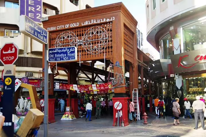 Entrance to Dubai's famous Gold Souk, bustling with tourists and adorned with traditional decor.