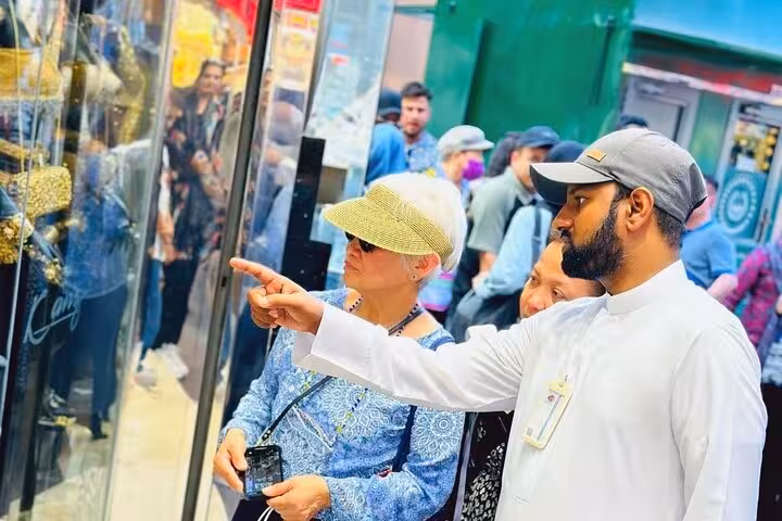 Dubai Gold Souk shopping stop on Dubai city tour from Ras Al Khaimah, guide showing jewelry displays