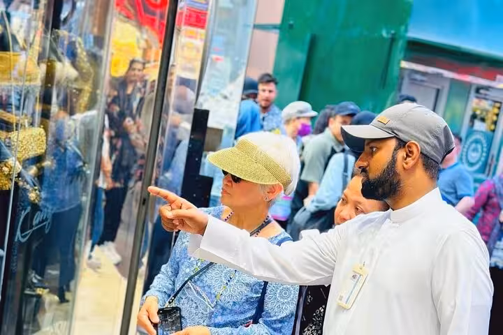 Tour guide showing travelers jewelry shops in Dubai Gold Souk during Dubai city tour with Ain Dubai entry