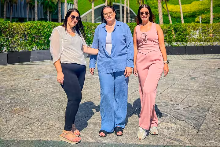 Three women pose outdoors in Dubai, showcasing vibrant fashion during a Dubai Layover Instagram Private Videography Tour.