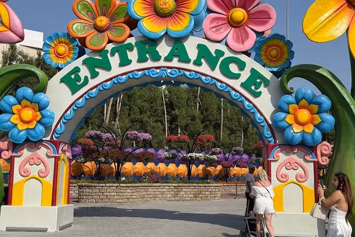 Colorful Dubai Miracle Garden entrance arch with giant flower decor, a popular stop on Ras AlKhaimah day tours