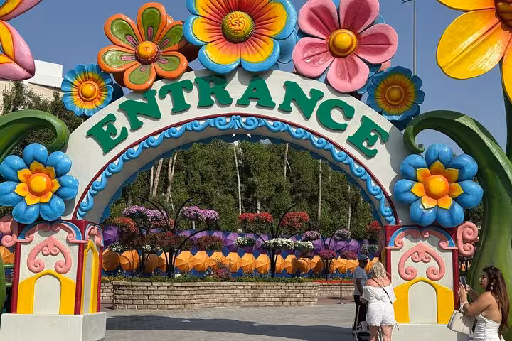 Colorful Dubai Miracle Garden entrance arch with flower sculptures, Fujairah to Dubai transfer tour included