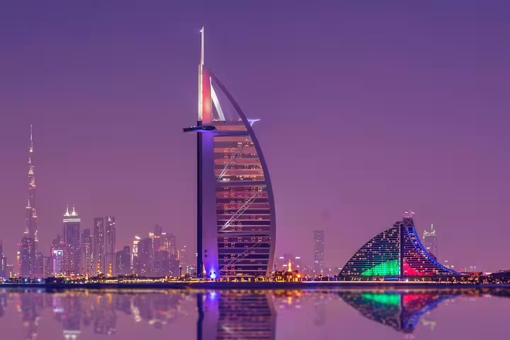 Stunning night view of Dubai's skyline featuring iconic skyscrapers illuminated against a vibrant purple sky.