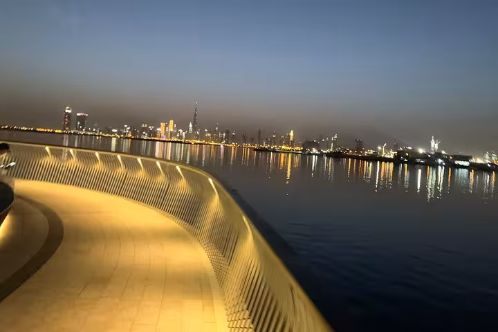 Dubai waterfront promenade at dusk with skyline reflections, ideal stop on a private Dubai by night tour
