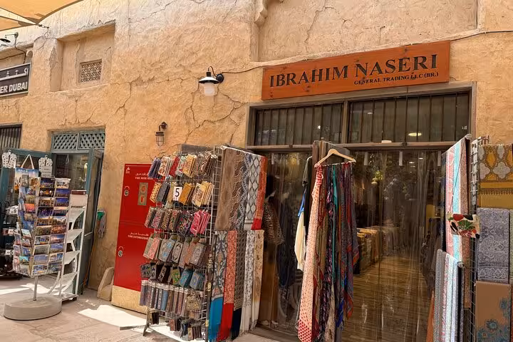 Dubai Old Souk shop with textiles and souvenirs on city tour combo including Ain Dubai entry