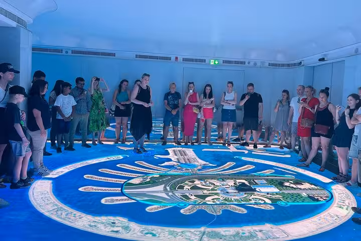 Tour group viewing Palm Jumeirah floor map on Palm Jumeirah tour with The View at The Palm entrance included