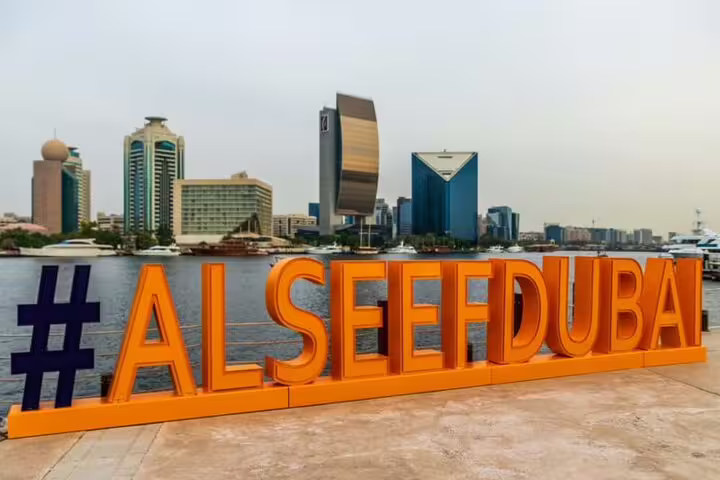 View of Dubai skyline with Al Seef Dubai sign, showcasing modern architecture along the waterfront.