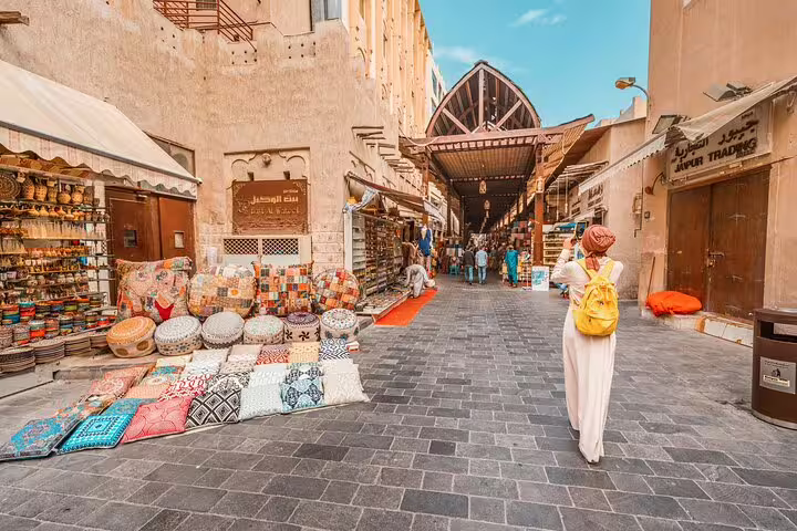Traveler browsing Dubai Old Souk textiles on a private layover tour, exploring Deira market highlights