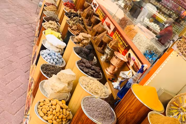 Colorful spice and dried fruit stall at Dubai souk, a popular shopping stop on Dubai city tour with Ain Dubai