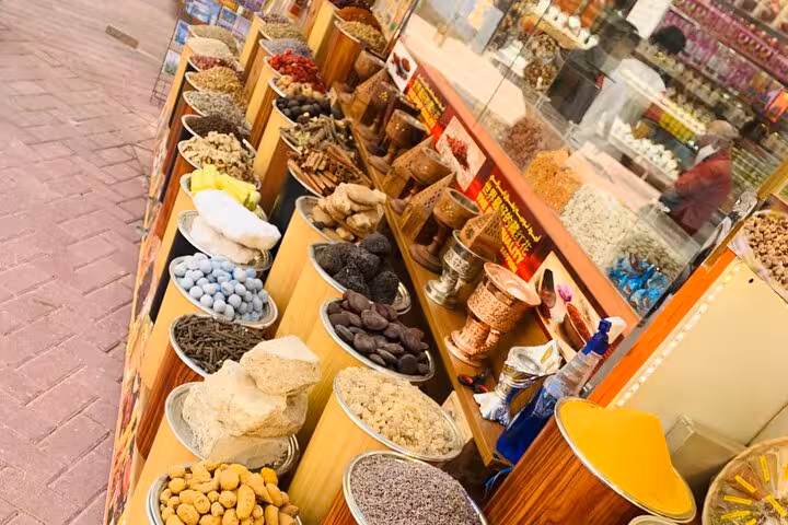 Old Souk spice stall with bowls of herbs, nuts and dried fruit on Dubai Creek sunset tour