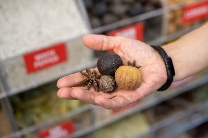 Hand holding mixed Middle Eastern spices in Dubai souk, showcasing flavors sampled on guided walking food tour
