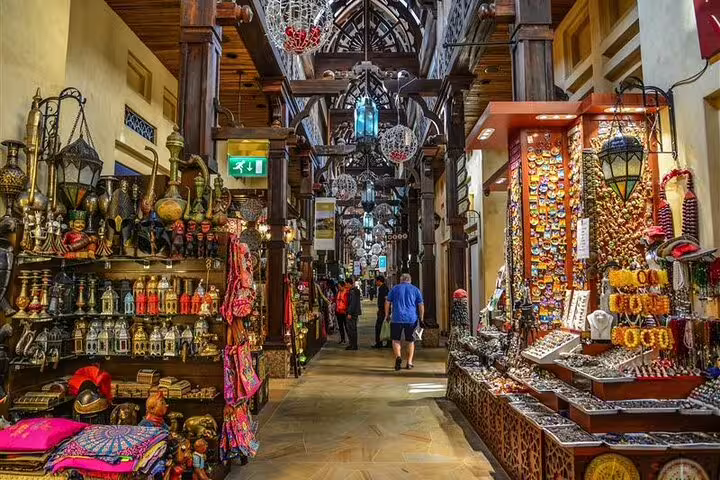 Wander through the vibrant, traditional souks of Dubai, showcasing colorful textiles and crafts, on a cultural private tour.