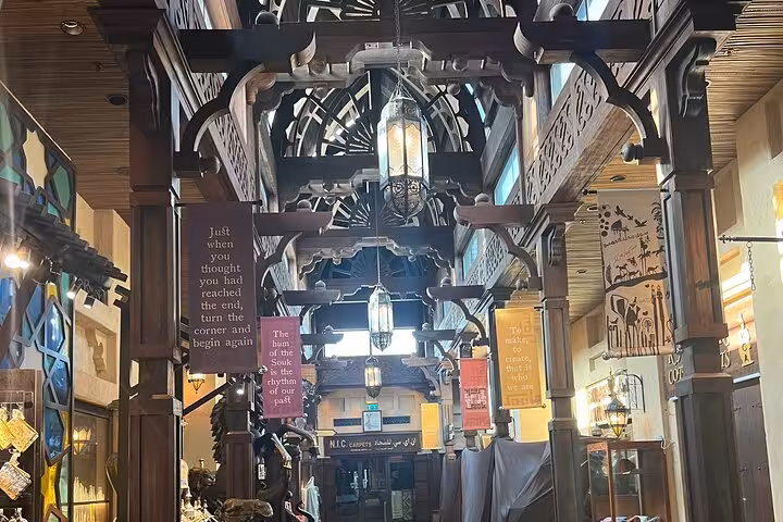 Traditional Dubai souk corridor with wooden arches and hanging signs, seen on Dubai city tour from Ras Al Khaimah