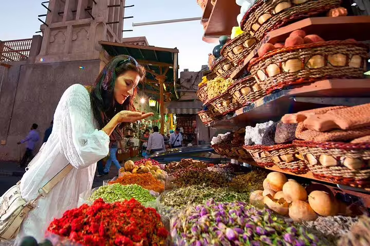Tourist exploring aromatic spices at Dubai's traditional market during a private city tour.