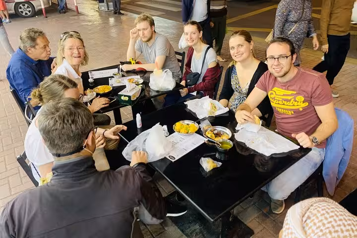 Tour guests enjoying Dubai street food tastings at an outdoor table on Old Dubai walking tour
