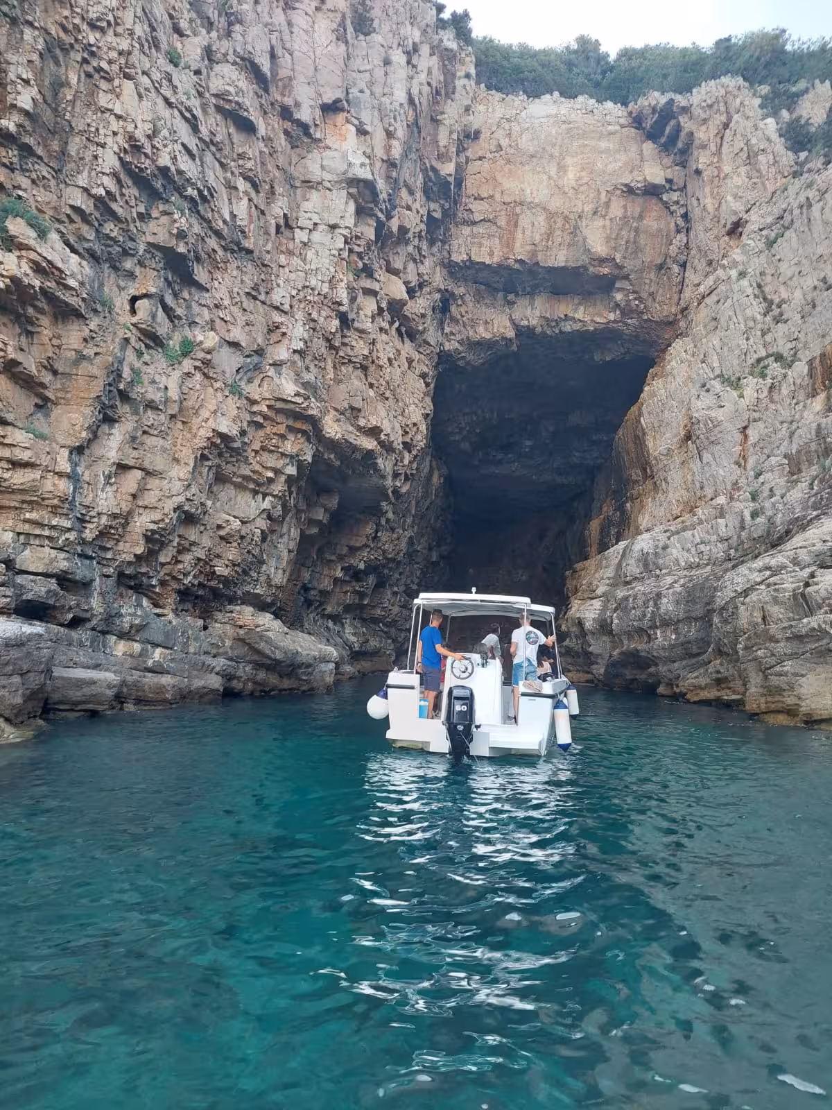 Boat tour entering sea cave near Dubrovnik, turquoise Adriatic water on Dubrovnik panorama by boat cruise