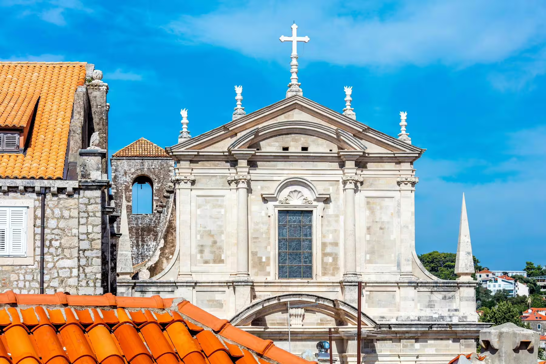 Baroque Dubrovnik church facade above terracotta rooftops, cultural sightseeing day trip from Makarska