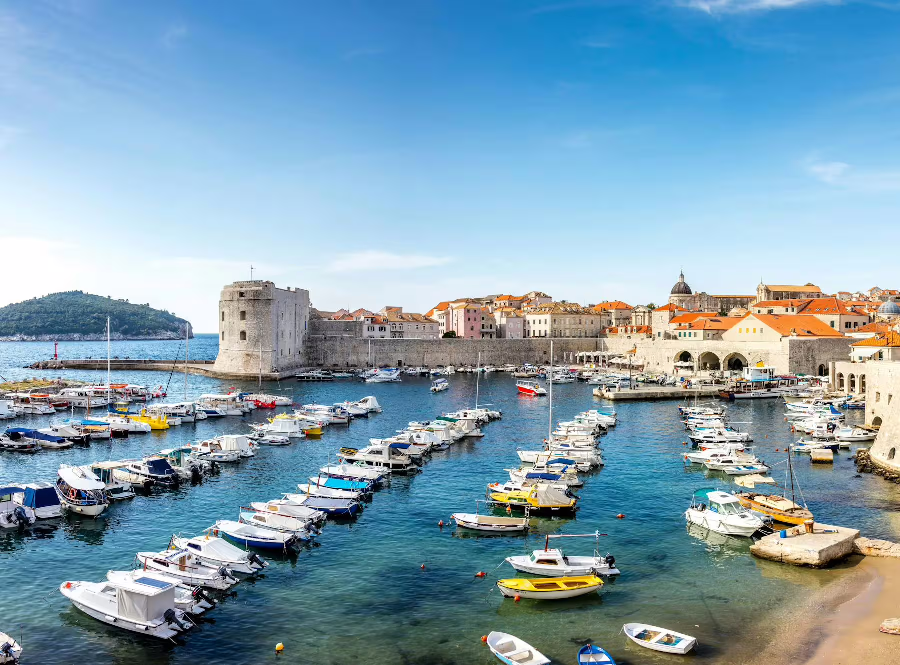 Dubrovnik Old Port with boats and Fort St John by the city walls, Makarska Riviera day tour