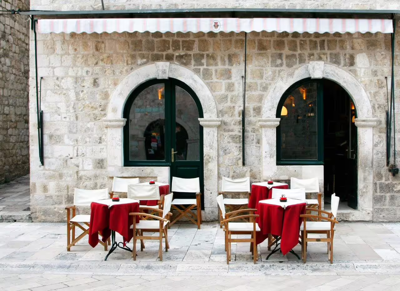 Outdoor café with red tablecloths in Dubrovnik Old Town, perfect stop on a private city break tour
