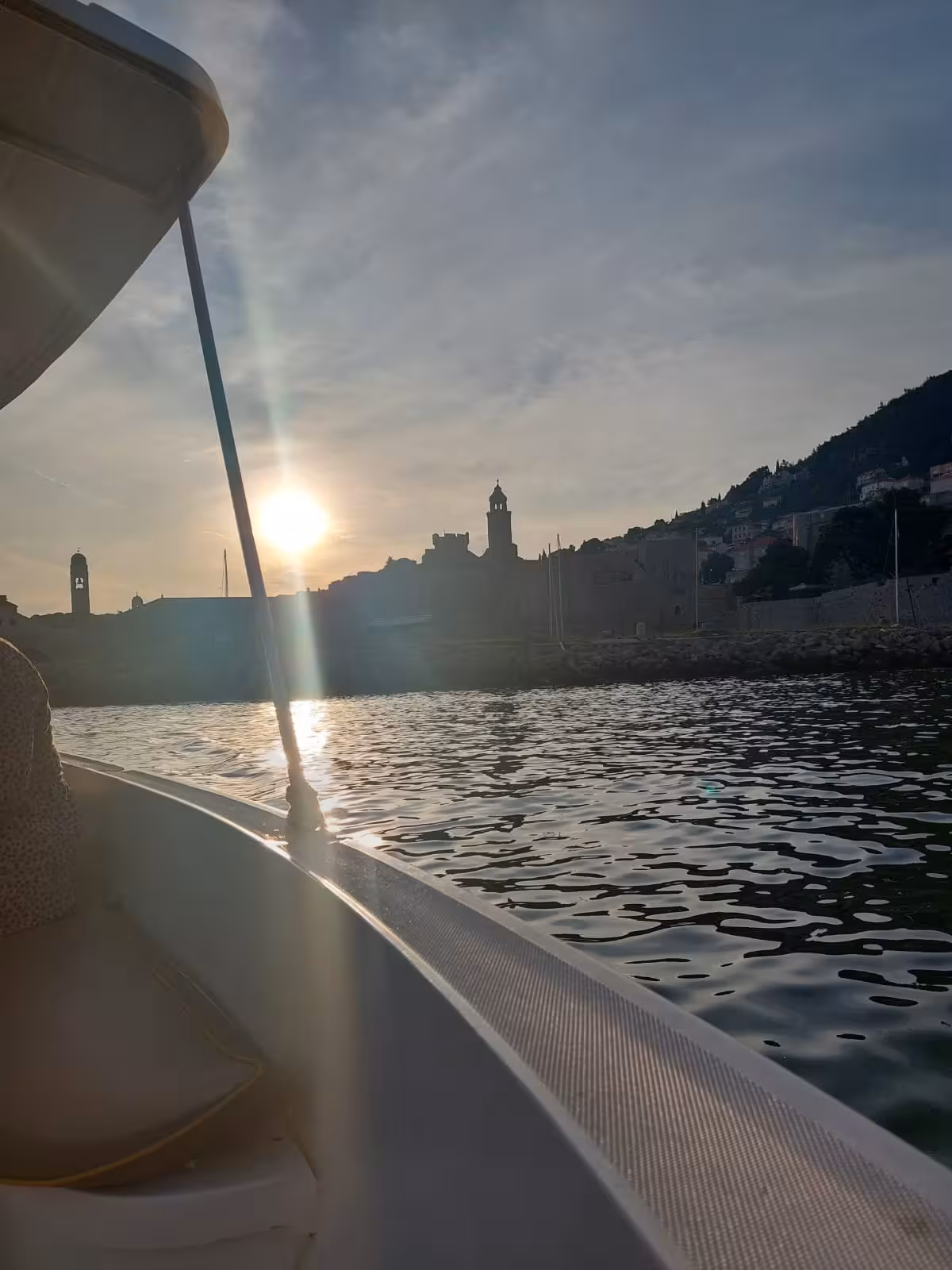 Sunset boat view of Dubrovnik Old Town walls and bell towers on History Walk & Dubrovnik panorama tour