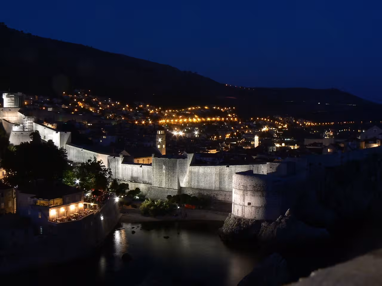 Dubrovnik Old Town walls illuminated at night, historic cityscape on exclusive evening walking tour