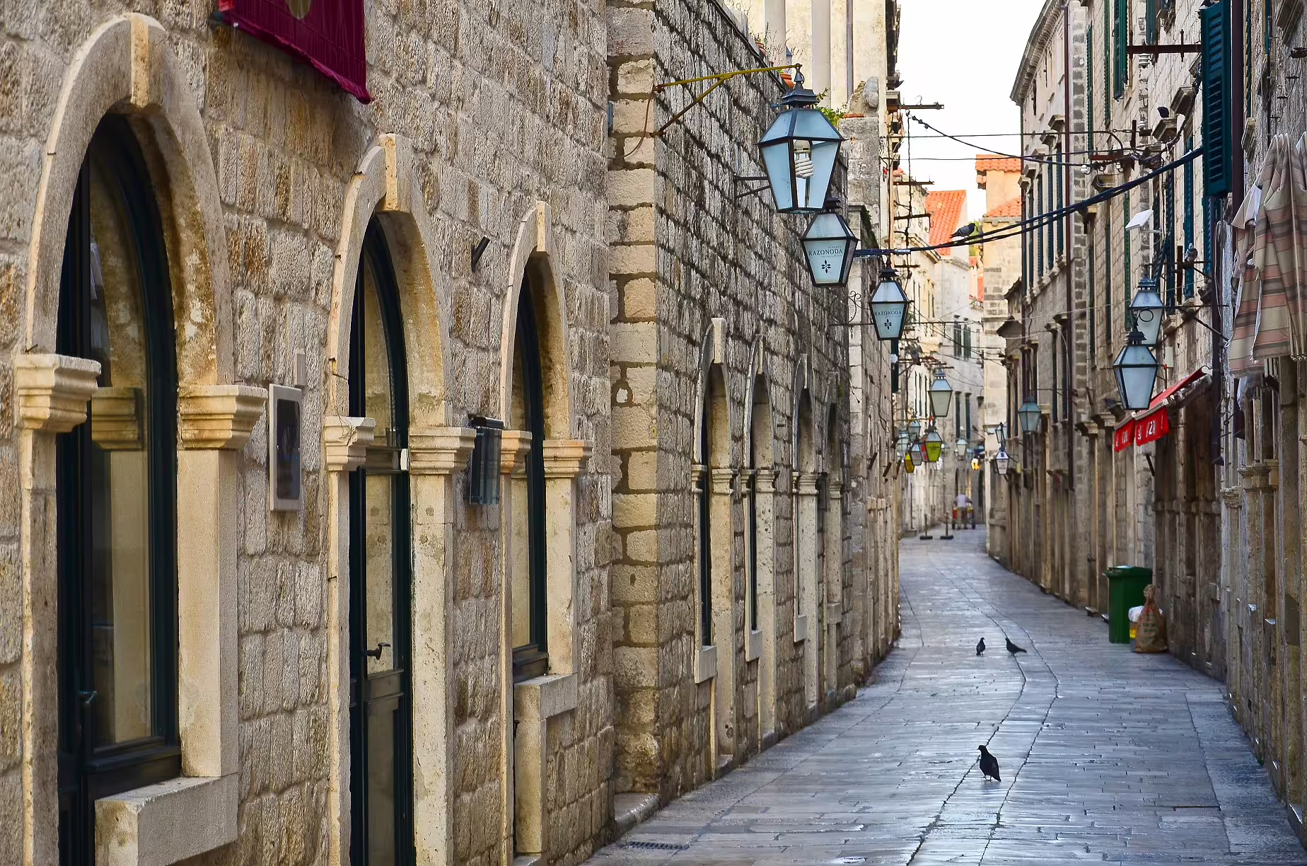 Quiet stone alley in Dubrovnik Old Town with lanterns, perfect for exploring on a Dalmatian Coast self-drive