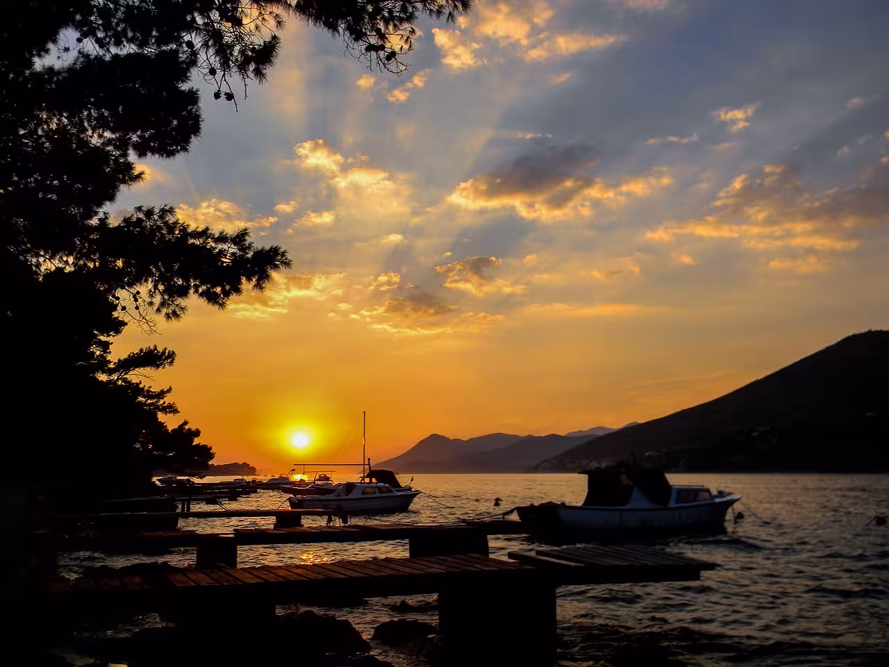 Sunset boat cruise near Dubrovnik with moored boats and Adriatic horizon, part of the exclusive evening tour