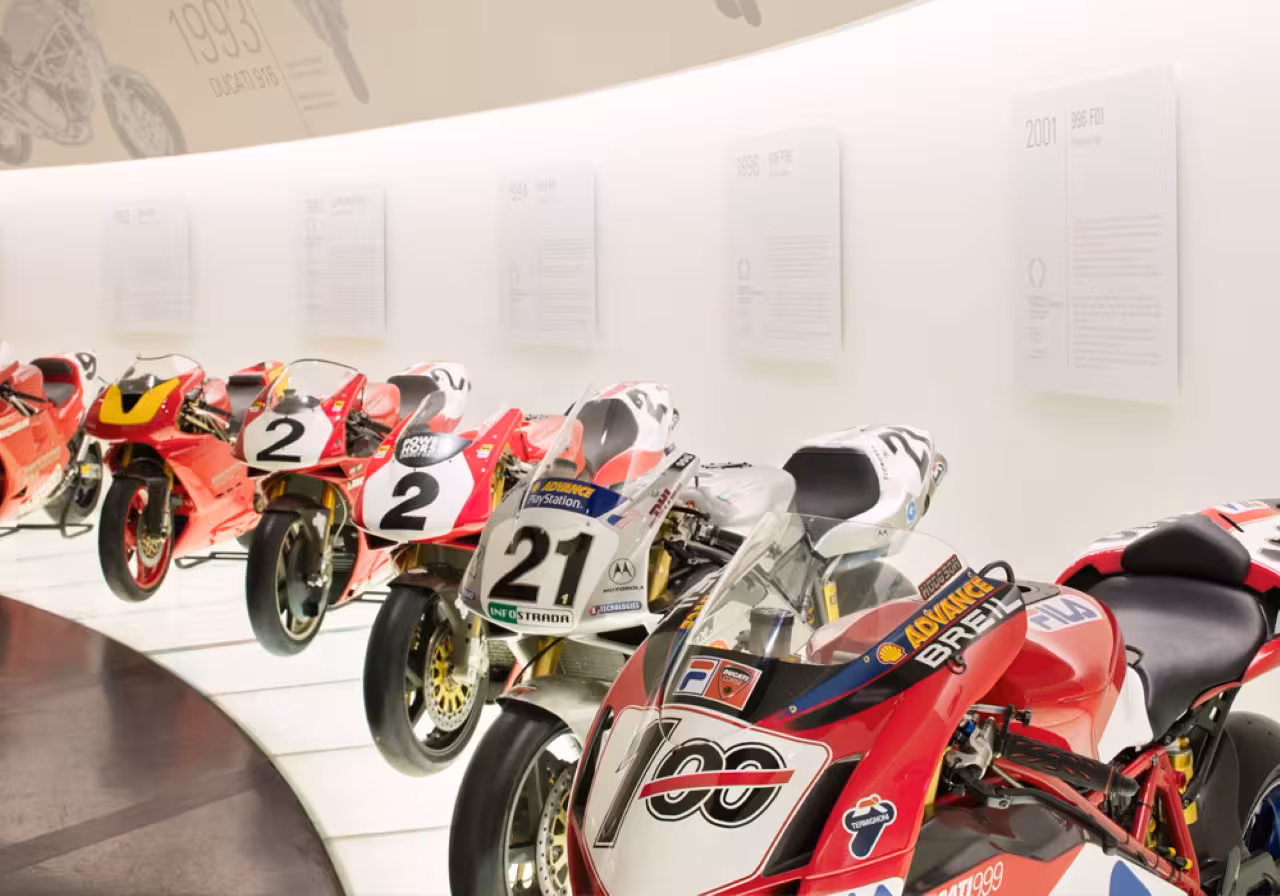 Row of Ducati MotoGP bikes at Ducati Museum Motor Valley, featured in Lamborghini and Ferrari museums combo pass