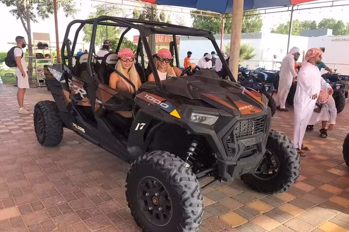 Guests seated in 4-seat dune buggy at desert camp, ready for guided quad bike and dune bashing tour