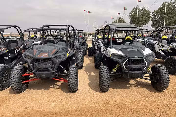 Row of dune buggy UTVs at desert camp staging area, ready for guided quad bike and dune bashing tour