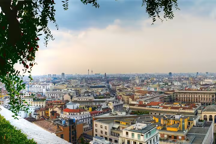 Panoramic rooftop view of Milan skyline at sunset, included in Duomo Cathedral private tour with local guide in Italy