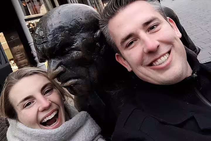 Couple selfie with Düsseldorf bronze statue in Old Town, part of a self-guided scavenger hunt and sights tour