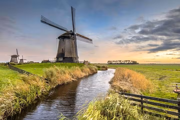 Dutch windmill by a canal at sunset on a private tour from Amsterdam exploring North Holland countryside