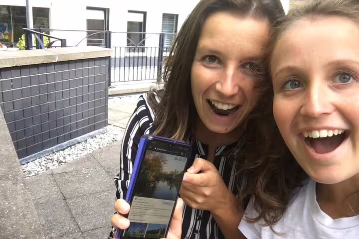 Friends using a smartphone for an e-scavenger hunt in Copenhagen, self-guided city exploration game