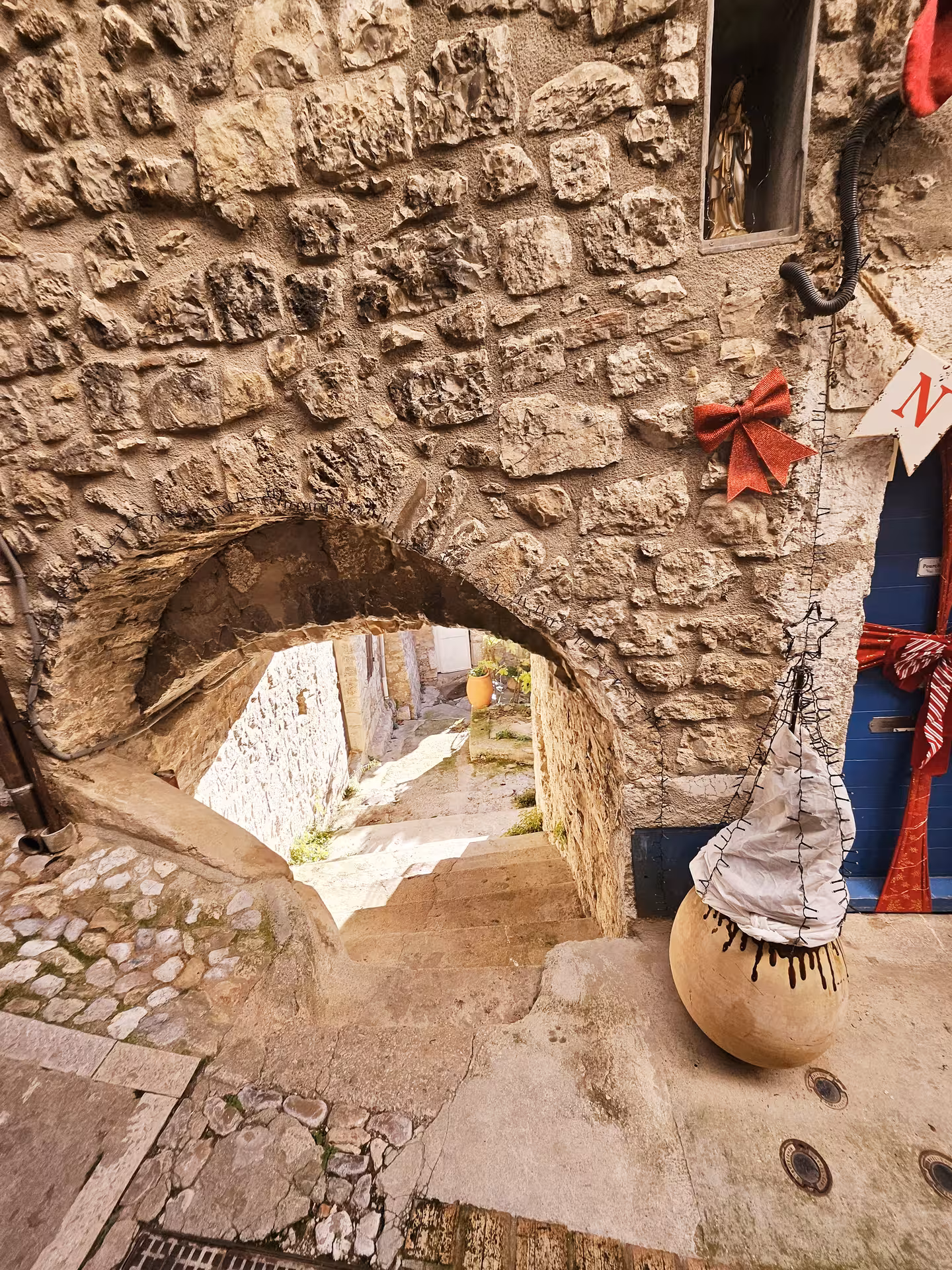 Charming stone archway and narrow cobblestone path in a quaint East Côte d'Azur hilltop village.