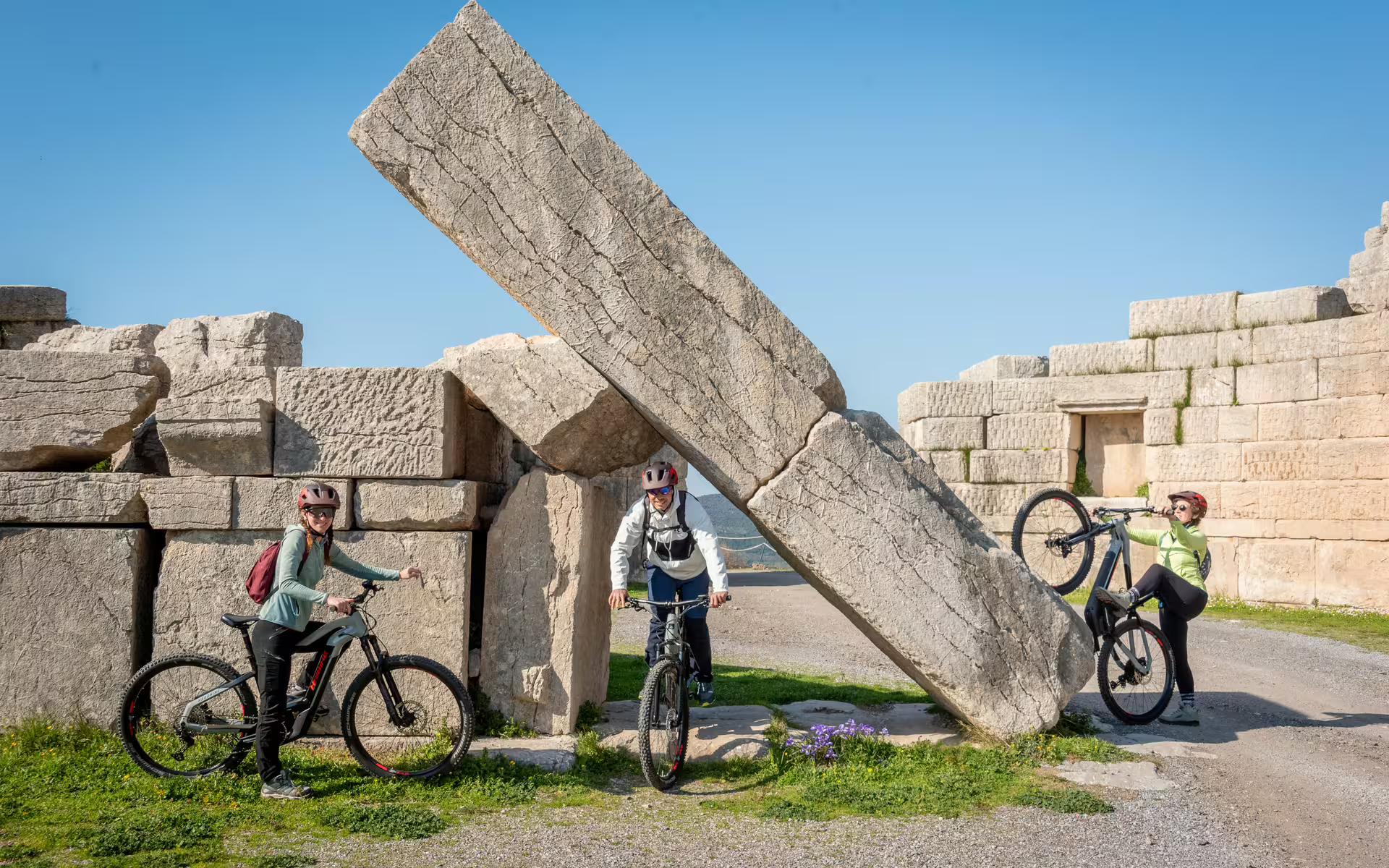 E-bike riders at Ancient Messene ruins by the Arcadian Gate, guided cycling tour in Messinia, Greece