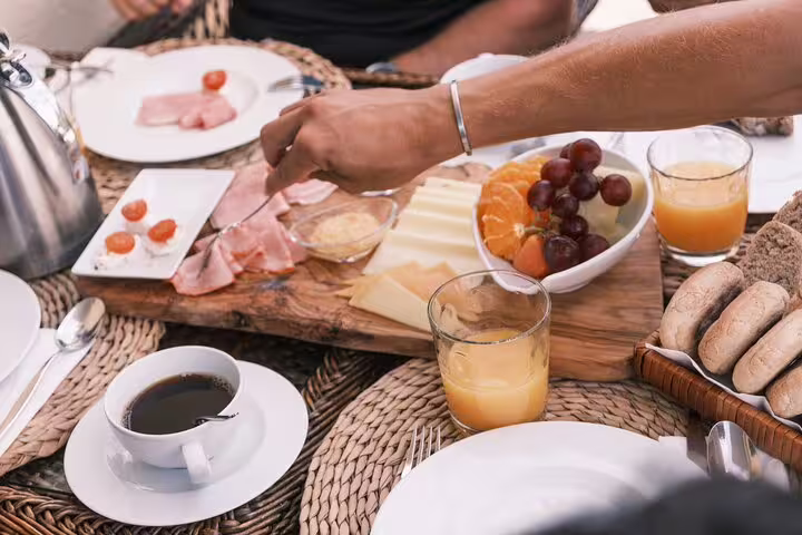A delicious breakfast spread featuring fresh fruits, cheeses, and meats, perfect for energizing your E-Bike Road Tour from Cabo Girão to Funchal.