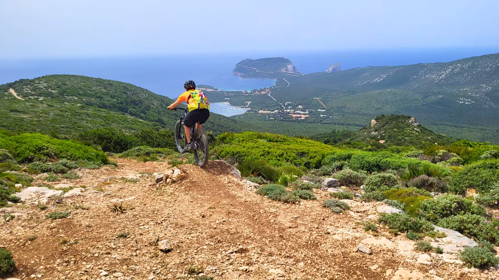 Cyclist enjoying a thrilling e-bike ride with stunning views of Porto Conte Park in Alghero.